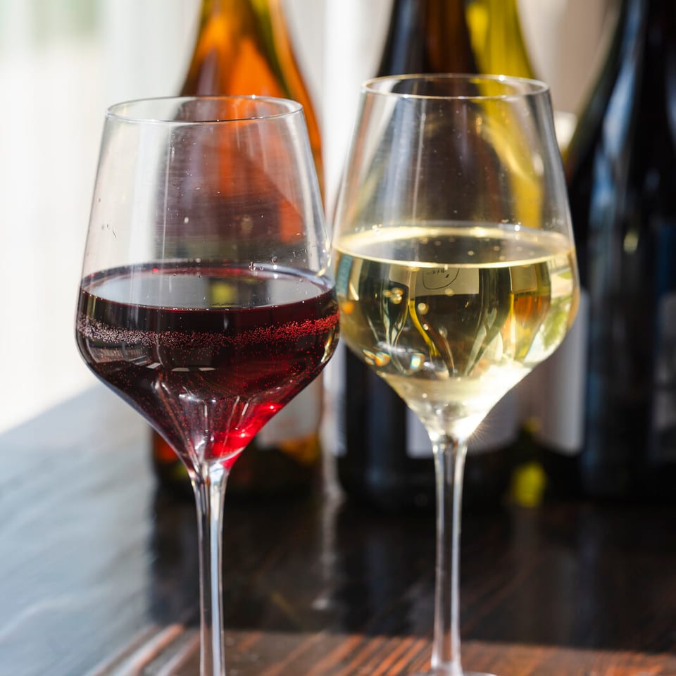 Two wine glasses on a wood table.